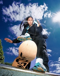 a girl is doing a trick on a skateboard