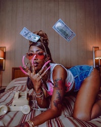 a woman laying on a bed with money in her hair