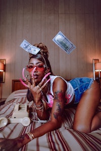 a woman laying on a bed with money in her hair