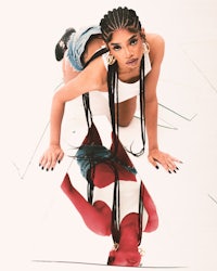 a woman crouching on the floor with a mirror in front of her