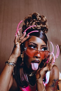 a woman with pink sunglasses and a tongue sticking out