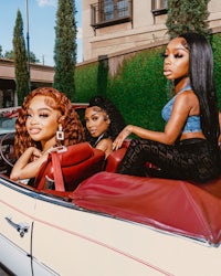 three women sitting in the back of a car