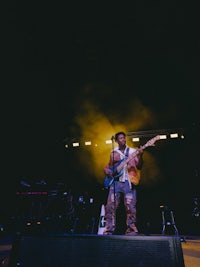 a man playing a guitar on stage at a concert
