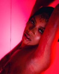 a woman with blood on her body posing in a red room