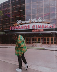 a man in a green jacket walking down the street