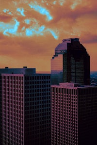 a city skyline with buildings and a plane in the sky
