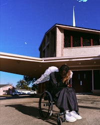 a woman sitting on a lounge chair in front of a building
