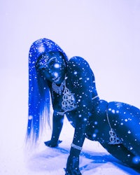 a woman with blue hair laying in the snow