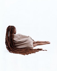 a woman with long dreadlocks laying on the ground