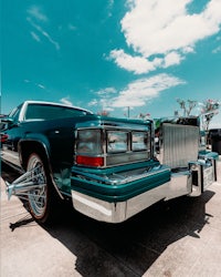 a green cadillac parked in a parking lot