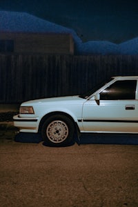 a white car parked on a street at night