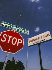 a stop sign next to a burger park sign