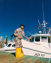 a man standing on a dock next to a boat