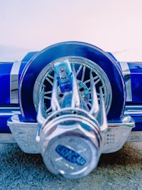 a blue car with a bottle in it's hood