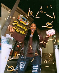 a woman is throwing confetti in front of a fast food restaurant